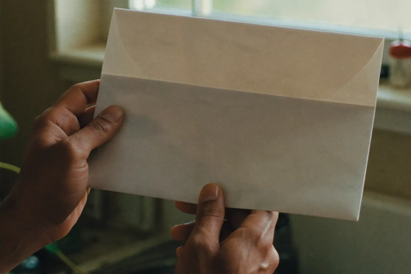 Unas manos abren un sobre de correo en la cocina
